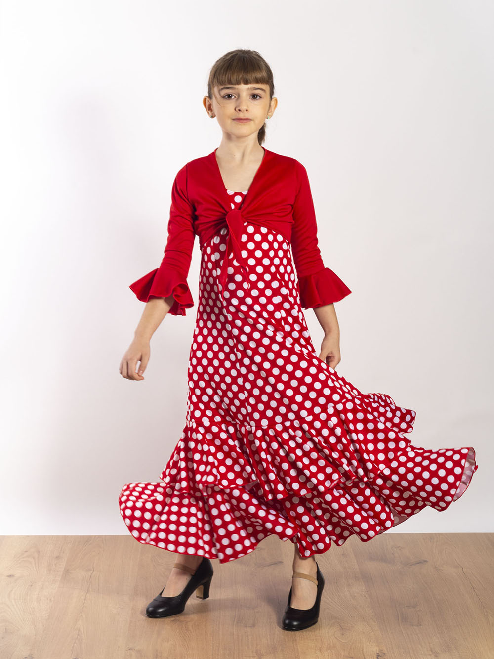 Vestido de baile flamenco infantil Amaya de Paralola. Color rojo con lunar blanco, se combina con un bolero rojo a juego.