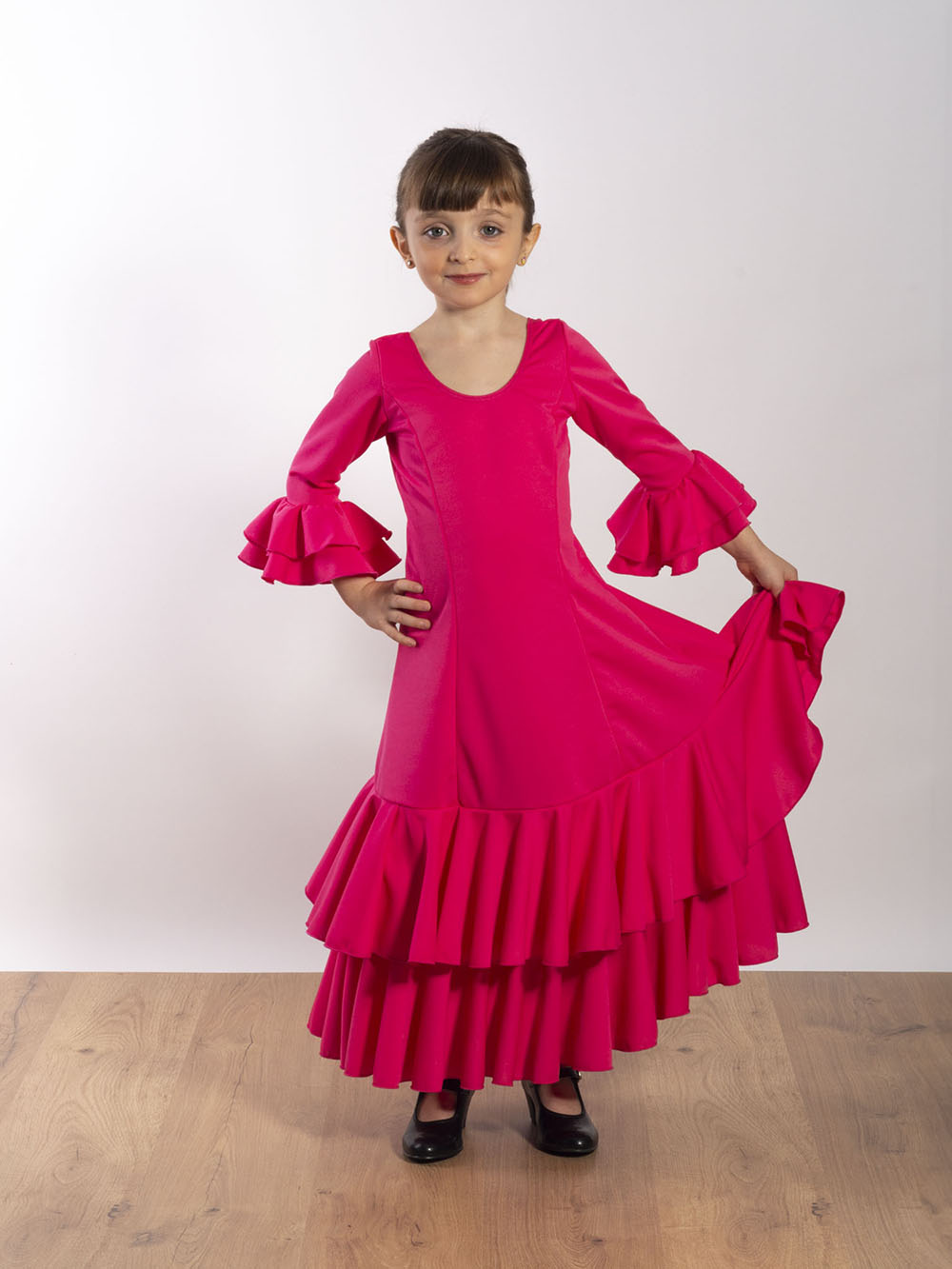 Vestido de baile flamenco infantil Rocío con mangas de Paralola en color rosa fucsia.